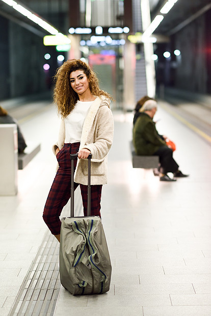 美丽的年轻阿拉伯女人地铁站等她的火车穿着休闲服的阿拉伯旅行者年轻的阿拉伯女人地铁站等她的火车图片