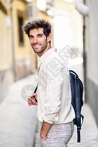 年轻人观光,享受格拉纳达的街道,西牙男旅行者携带背包城市背景年轻人观光享受格拉纳达的街道图片