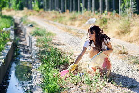 年轻的女人手收集农村草地的垃圾女人手收集农村草地的垃圾图片