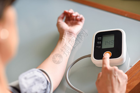 中年妇女家里用电子血压测量装置测量自己的血压女人家里测量自己的血压图片