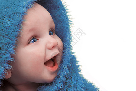 美丽的微笑婴儿裹着毛茸茸的蓝色毯子图片