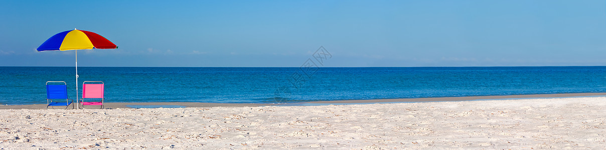 全景网络横幅粉红色蓝色甲板椅子个空荡荡的海滩下,五颜六色的雨伞或阳伞图片
