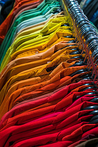 男式衬衫按颜色顺序排列商店衣柜壁橱栏杆上的衣架上图片