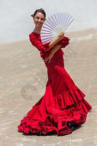 西牙女弗拉门戈舞者穿着红色连衣裙外面表演,摆着白色扇子图片