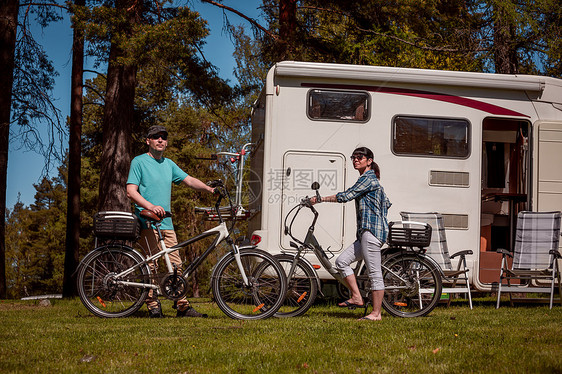 女人个骑电动自行车的男人营地休息家庭度假旅行,假日旅行汽车房车,商队汽车度假图片