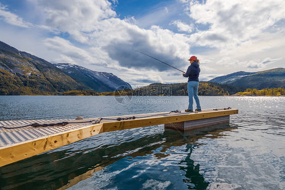 挪威钓鱼的女人钓鱼竿上挪威钓鱼拥抱当地生活方式的种方式无数的湖泊河流广阔的海岸线意味着杰出的机会图片