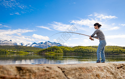 挪威钓鱼的女人钓鱼竿上挪威钓鱼拥抱当地生活方式的种方式无数的湖泊河流广阔的海岸线意味着杰出的机会背景图片