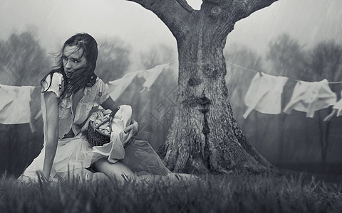 个可怜的女人雨天洗衣服的肖像图片