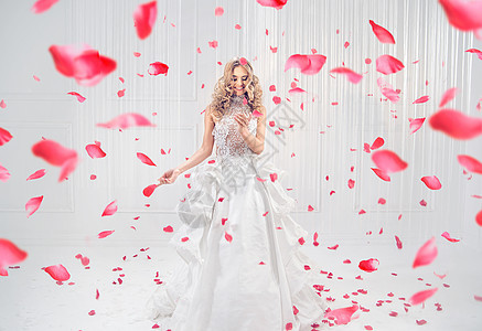 漂亮,优雅的金发女郎红玫瑰花瓣跳舞图片