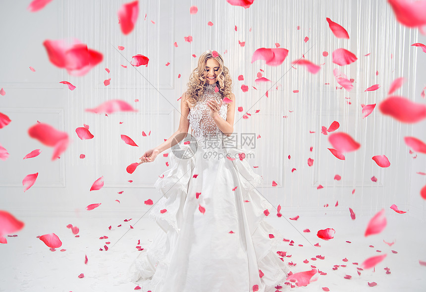 漂亮,优雅的金发女郎红玫瑰花瓣跳舞图片
