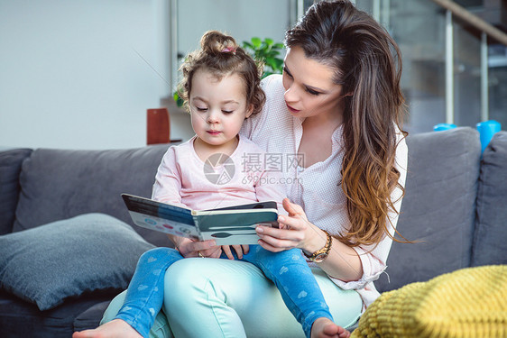 年轻的母亲她的小女儿读了本书图片