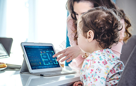 女人教她可爱的女儿平板电脑处理图片