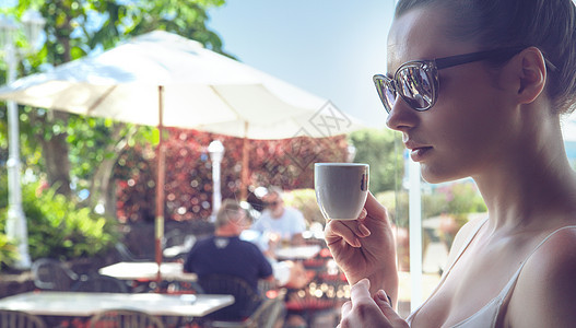 个迷人的女人喝咖啡的肖像图片