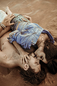 闷热潮湿感的年轻夫妇躺热带沙滩上背景