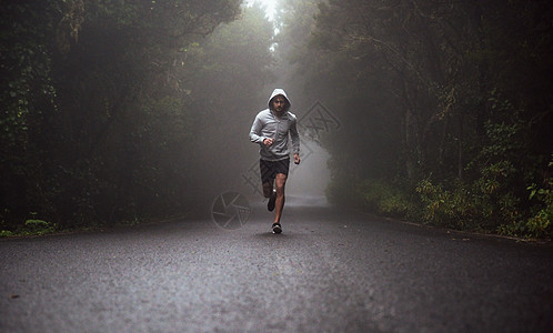 个年轻疲惫的运动员路上跑步的肖像图片