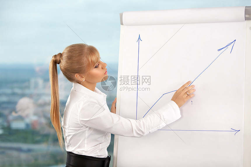 办公室里的商务妇女把时间表画黑板上