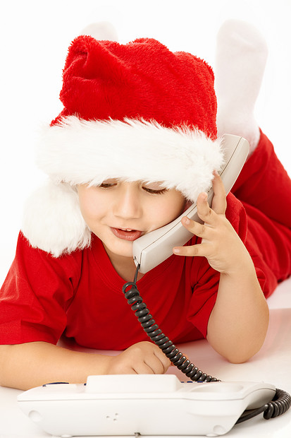穿着圣诞老人衣服的小男孩撒谎,打电话