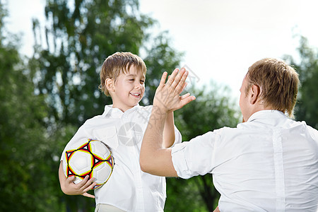小儿子足球运动员欢迎父亲,夏天图片