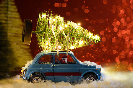 圣诞老人开着蓝色复古玩具车送圣诞树图片