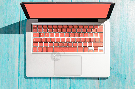 笔记本电脑与生活珊瑚色键盘木桌上的阳光明媚的天,上面看木制桌子上的笔记本电脑图片