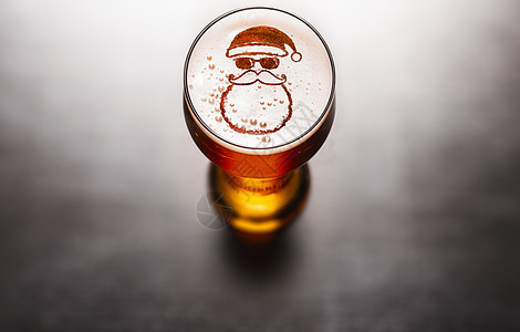 圣诞节或新年啤酒黑色桌子上啤酒玻璃泡沫上的星星符号,上面看圣诞节或新年啤酒图片