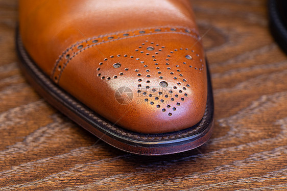 棕色的男式全纹皮鞋脚趾,特写全纹皮革棕色鞋的脚趾图片