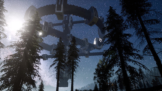UFO夜间用光束盘旋森林上空图片
