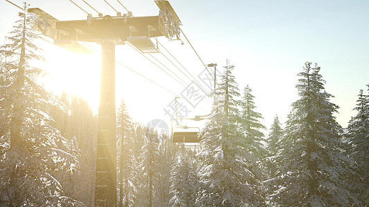 空的滑雪缆车日落时,森林上空的高山上,椅子上的剪影图片