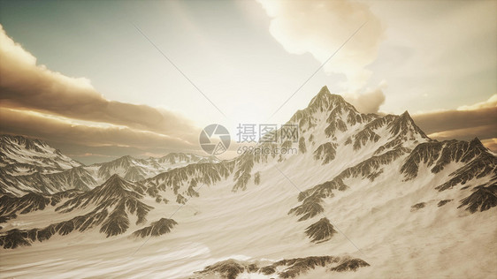 中亚高山全景,日落时有大的岩石墙冰川日落时高山的全景图片