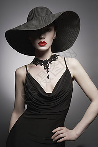 时尚肖像年轻感女士与美丽的黑色帽子晚礼服时尚优雅的女人与现代珠宝灰色背景上漂亮模特的工作室照片背景图片