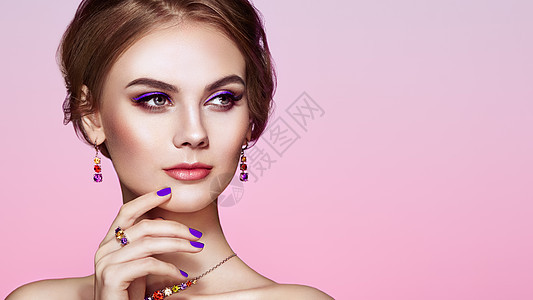 用珠宝描绘美丽的女人模特女孩用紫罗兰指甲修剪指甲优雅的发型紫色化妆箭头美容配饰背景图片