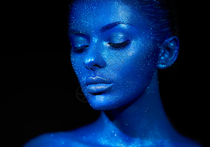 时尚模特女人穿着蓝色明亮的火花霓虹灯工作室摆姿势美丽感女人的肖像艺术彩色闪光发光化妆图片