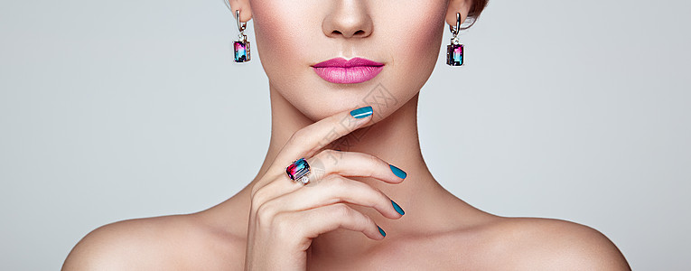 用珠宝描绘美丽的女人指甲上有蓝色指甲的模特女孩美容配饰粉红色口红图片