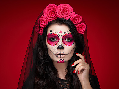 红色背景上有糖头盖骨化妆的女人的肖像万圣节服装化妆卡拉韦拉卡特里娜的肖像图片