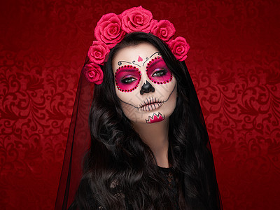 红色背景上有糖头盖骨化妆的女人的肖像万圣节服装化妆卡拉韦拉卡特里娜的肖像图片