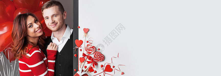 美丽的夫妇与情人节装饰红心,丝带,棒棒糖草莓,白色的文本夫妇心装饰图片