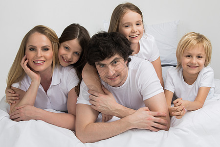 父母三个孩子父母三个孩子床上幸福的家庭床上图片