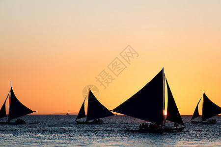 帆船橙色日落背景下的轮廓日落时的帆船图片