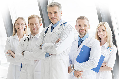 成功的医生队正看着相机,微笑着站医院里交叉双臂成功的医生队图片