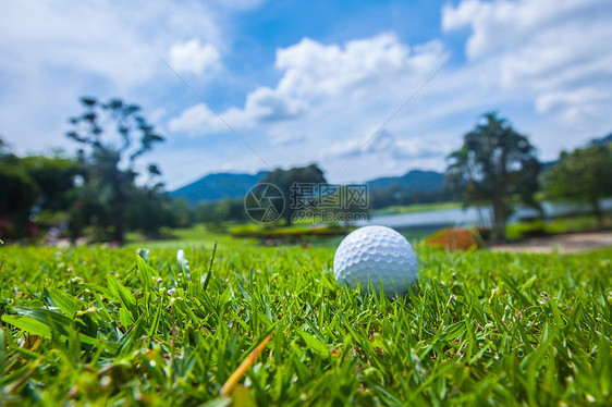球场上的高尔夫球,背景上有湖山的美丽景观球场上的高尔夫球图片