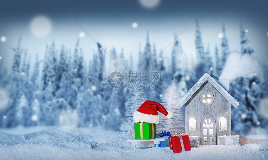 圣诞卡,舒适的小装饰房子,礼物圣诞老人的帽子,雪橇上的雪,童话冬天的冷杉森林背景下雪新年明信片文本圣图片