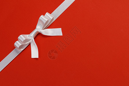 白色礼品蝴蝶结红色背景节日礼品白色礼物蝴蝶结红色图片