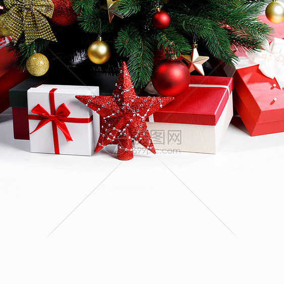 装饰的圣诞礼物星星树下与白色背景上白色背景圣诞树下的圣诞礼物图片