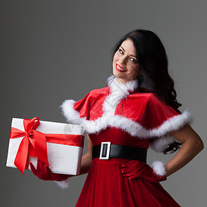 微笑可爱的女孩穿着红色圣诞装着礼品盒带圣诞礼盒的女孩图片