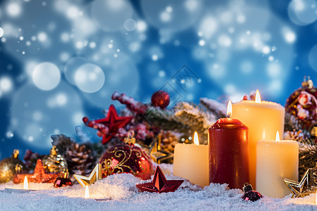 圣诞蜡烛与传统的装饰星星,红宝贝,松果绿色的树枝雪上带有装饰的圣诞蜡烛图片