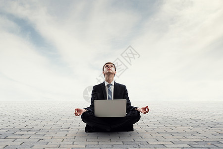 商人坐莲花的姿势,膝盖上放着笔记本电脑找到内的平衡图片