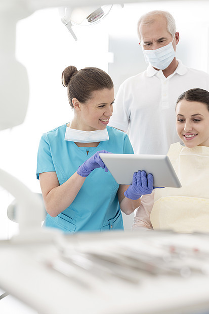 微笑牙医与病人讨论数字平板牙科诊所图片