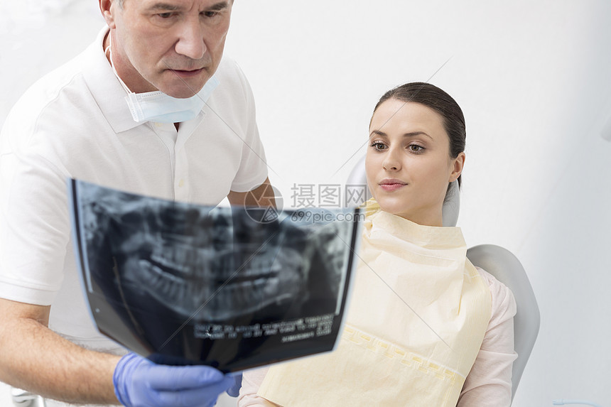 牙科医生的高角度视图X光给牙科诊所的病人图片