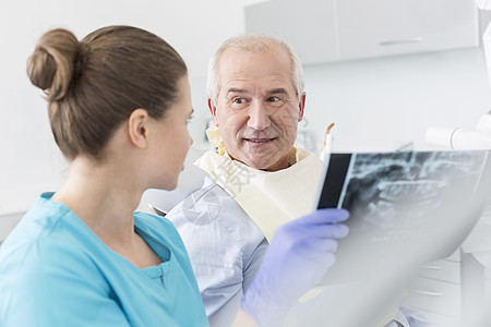 牙医高级病人诊所讨论X光图片