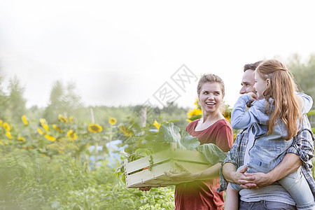 微笑的家庭带着蔬菜农场散步图片